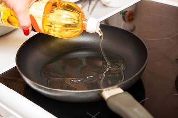 hands pour sunflower oil