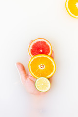 Lime, orange and grapefruit in the palm of your hand. citrus fruits in murky muddy milky water. Citrus traffic light. A lot of free space for text.