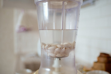 Blender and almonds soaked in water. Homemade healthy vegan milk.