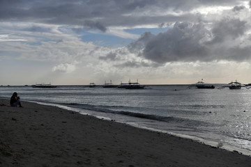 fishing boats stunning sea and unusual clouds at sunset on a tropical island