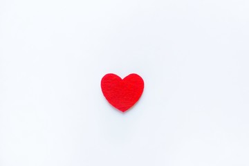 Red heart made of felt on a white background. Valentine's day symbol, holiday concept, minimal style. Top view with copy space for text.