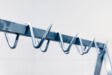 Metal meat hook or hangers in a row in a butchery slaughter house