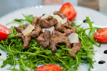 Tasty and juicy grilled meat with arugula, cheese, tomato sauce and spices
