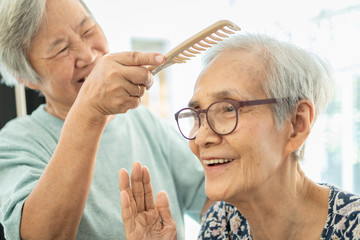 Happy asian elderly women,female senior combing hair to friend senior woman in nursing home,smiling old people or sister care,support,talk, good time together, sprightly, friendship of retirement age - obrazy, fototapety, plakaty