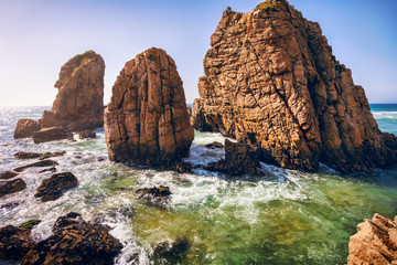 Obraz na płótnie Canvas Ursa beach, Sintra, Portugal. Epic sea stack rocks rising from atlantic ocean in sunset light