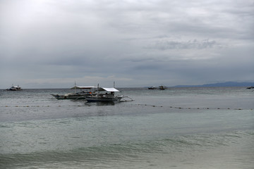 fishing boats stunning sea and unusual clouds at sunset on a tropical island