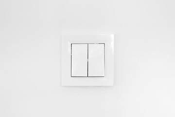 White double light switch mounted on a white wall