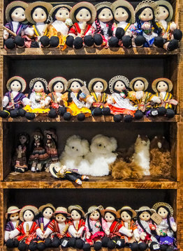 Traditional South American hand made cloth dolls in traditional clothing displayed on shelves in indigenous craft market