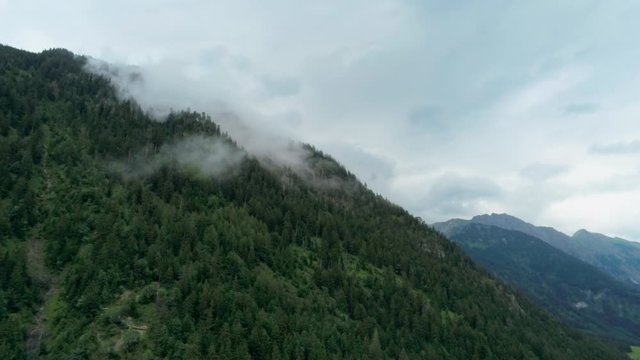 Scenic Aerial View of Mountains with Steam and Forest. Cinematic Environment Background Footage of Natural Landscape in Alps, Germany. 4K Drone Pull in Panoramic Shot