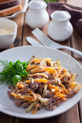 Minced salad of boiled beef and egg pancakes on a white plate, selective focus