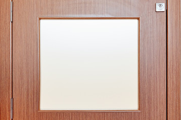 Bottom section of an office door with frosted glass window and lock