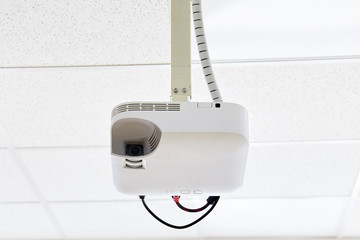 White projector hanging on the ceiling