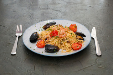Spaghetti pasta with shrimp, mussels, tomatoes and cheese. Tasty, traditional Italian food