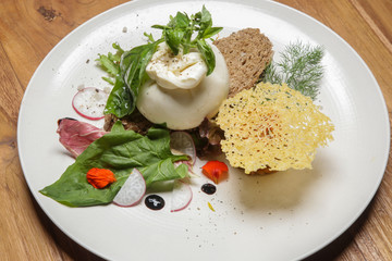 Fresh buratta cheese, toasted cereal bread with herbs and green leaf salad	