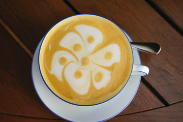Cup of warm cappuccino coffee with a flower foam design on top