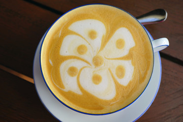 Cup of warm cappuccino coffee with a flower foam design on top