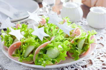 Cold festive appetizer of sliced ham, boiled egg and lettuce, selective focus