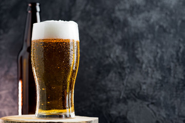 Cold beer lager in a glass on a dark background