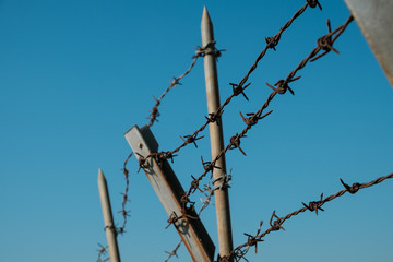 barbwire closeup on fence, barbed wire on blue sky