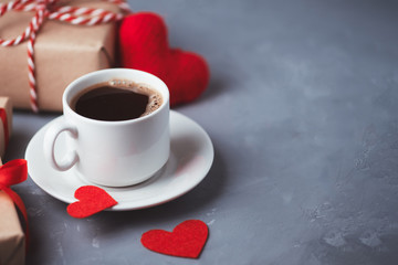 A Cup of hot coffee, red hearts and a gift for Valentine's day. Romantic morning