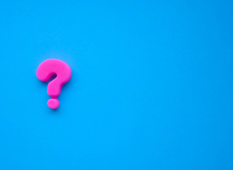 pink question mark on a blue background. Background photo with place for text.