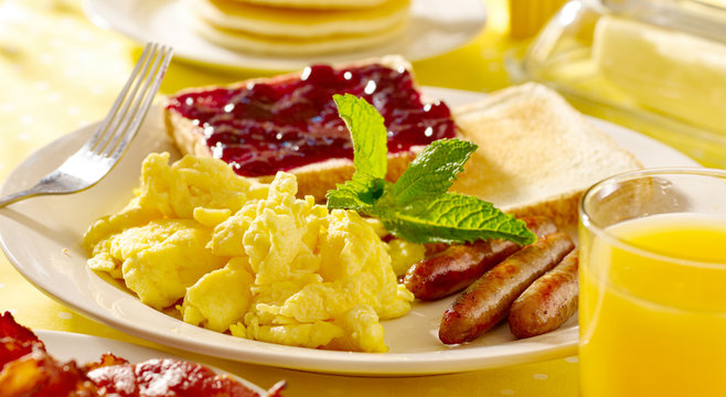 Breakfast With Scrambled Eggs, Sausage Links And Toast.