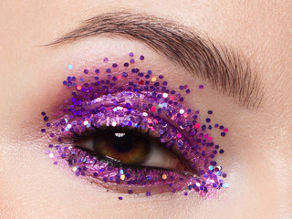 Close eye with colorful eyeshadow. Macro shot of opened human female eye. Woman with evening beauty...