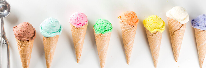Colorful pastel ice cream with waffle cones, white background, copy space top view