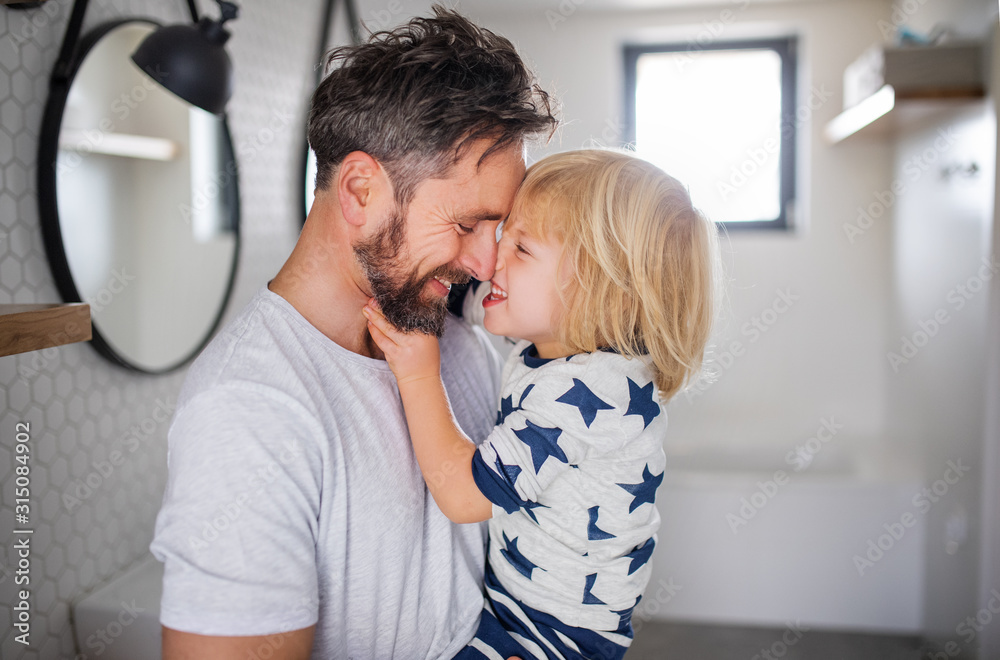 Wall mural Mature father with small son indoors in bathroom, having fun.