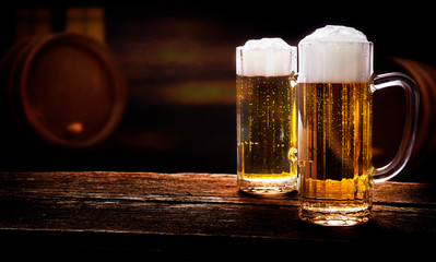 Two beer glasses on wooden table in a pub
