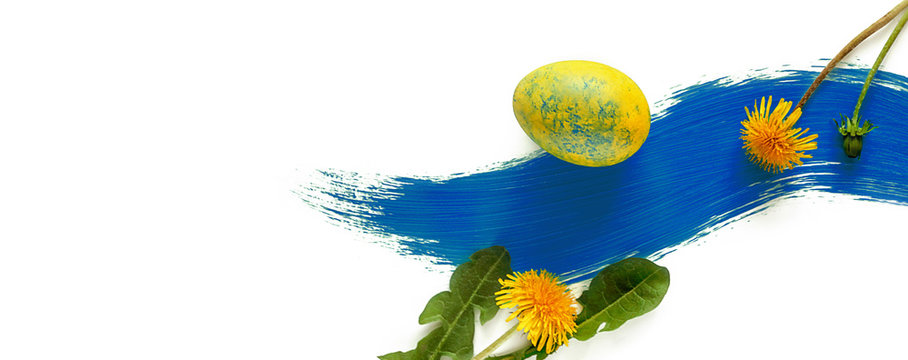 Easter Background. Easter Eggs And Dandelion Flowers On A Smear Of Blue Paint. Modern Art. Selective Focus. Banner.