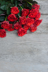 Bouquet of red roses on wooden background. Birthday. Valentine's day. March 8. Mother's day. Greeting card. Wallpaper. Banner.
