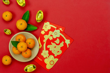 Chinese character means fortune and luck.Accessories on Lunar New Year & Chinese New Year vacation concept background.Red envelop and pink flower with orange on modern red wallpaper.copy space.