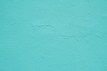 Texture of light blue leaked paint on a concrete wall.