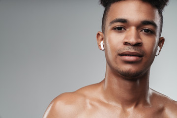 Photo closeup of shirtless african american man using earpods