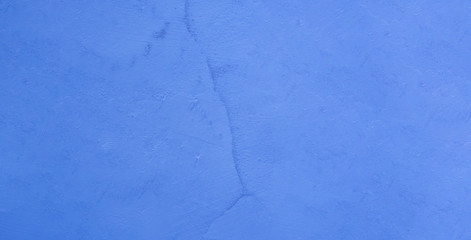 Texture of cracked old light blue stucco.