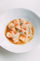  Restaurant seafood dish. Original cuisine. Fresh scallops on a plate. Red caviar in a dish.