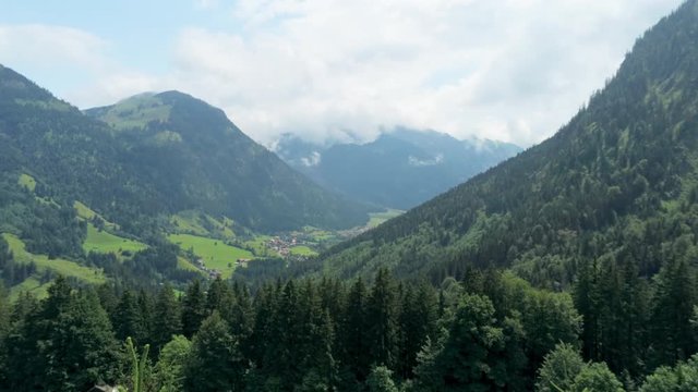 Majestic Aerial View of Alpine Village in Mountains. Amazing Countryside Scenery of Nature in Alps, Bavaria, Germany, Europe. 4K Drone Pull in Shot