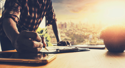 Business designers are using the pen to check the trade balance from the graph. © teerapon