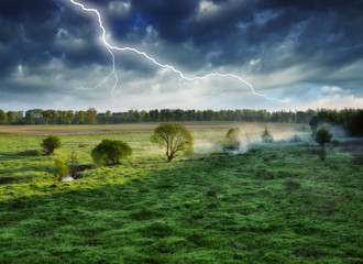 lightning in the sky. morning in a picturesque meadow. spring thunderstorm