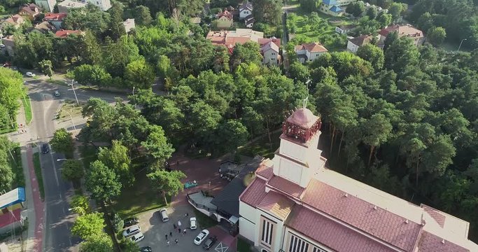 Duży biały kości&oacute;ł w centrum miasta między drzewami z lotu ptaka