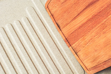 Wooden board for butchering meat lies on kitchen sink.