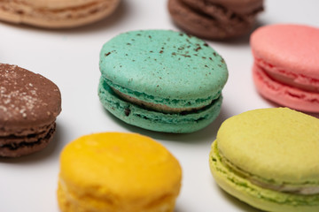 Close-up pattern from colorful French macaroons on white background. Flat lay. Selective focus