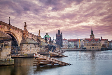 Charles Bridge and historical buildings of old town on Vltava riverbank in Prague at sunrise, Czech Republic, Europe.