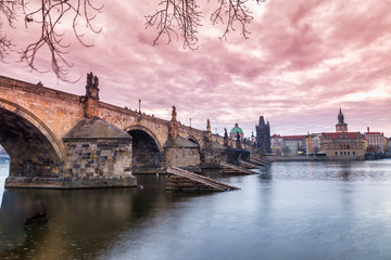 Obraz premium Charles Bridge and historical buildings of old town on Vltava riverbank in Prague at sunrise, Czech Republic, Europe.