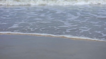 Sea waves close up during inflow on sand