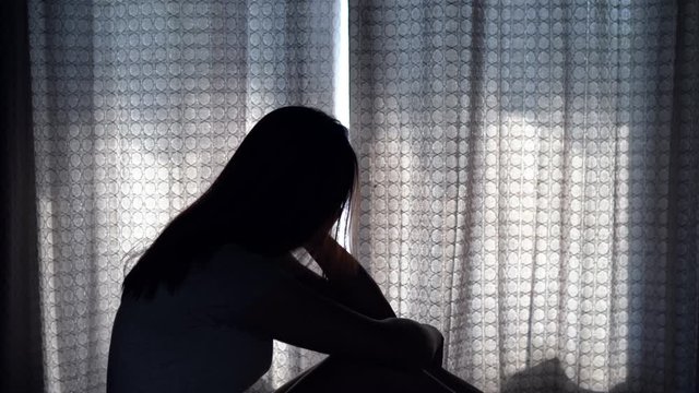 Lonely young woman feeling depressed and stressed sitting head in hands in the dark bedroom, Negative emotion and mental health concept