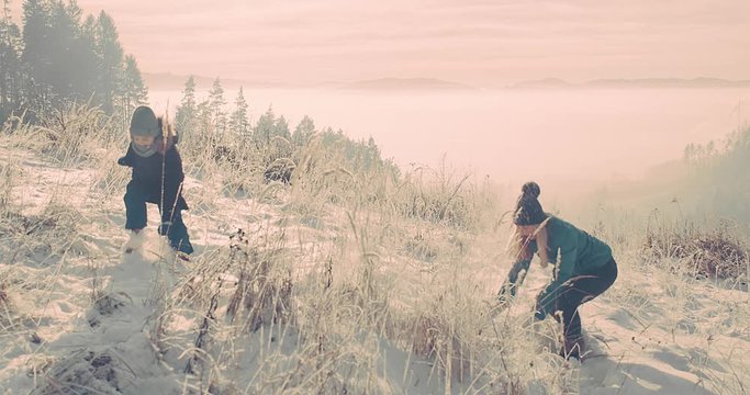 Family winter holiday, mother and child having fun running between snow trees in winter forest, beautiful snow landscape. Travel together concept.