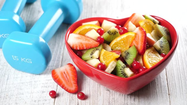 fruit salad and dumbbell-fitness and diet food concept