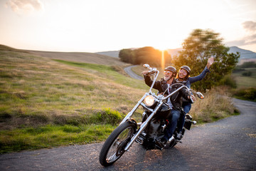 Fototapeta Cheerful senior couple travellers with motorbike in countryside. obraz